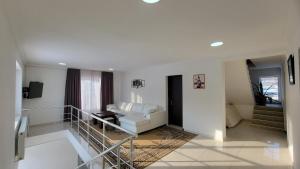 a living room with a white couch and a staircase at Cottage in Bakuriani