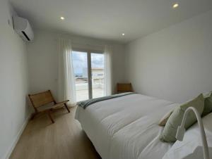 ein Schlafzimmer mit einem großen weißen Bett und einem Fenster in der Unterkunft Villa Islander in Cala Morell + 19 Fotos