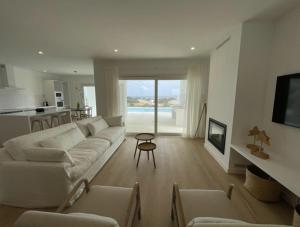 ein Wohnzimmer mit einer weißen Couch und einem Tisch in der Unterkunft Villa Islander in Cala Morell
