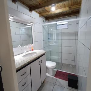 a bathroom with a sink and a toilet and a shower at Dunas Tiny House Casa 2 in Florianópolis