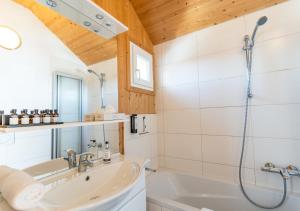 1A Chalet Eck - Wandern und Grillen, Panorama Sauna! في Klippitztorl: حمام مع دش ومغسلة وحوض استحمام