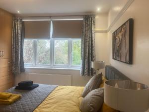 Schlafzimmer mit einem Bett und einem großen Fenster in der Unterkunft Large, Spacious Home in London with Modern Interior in Finchley