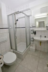 La salle de bains est pourvue d'une douche, de toilettes et d'un lavabo. dans l'établissement Ambiente by Next Inn, à Hambourg
