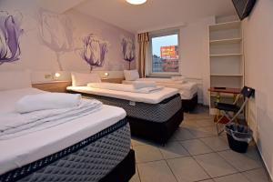 a hotel room with two beds and a window at Ambiente by Next Inn in Hamburg