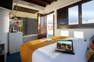a room with a bed with a tablet on it at Casual Ilbira Granada by Casual Hoteles in Granada