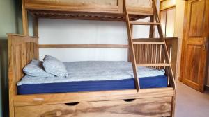 a bunk bed with a wooden bunk bed with a ladder at Bavaria Homes in Kasusu