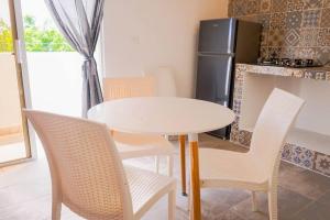 a white table and chairs in a kitchen with a refrigerator at Apartamentos estudio amueblados in Punta Cana