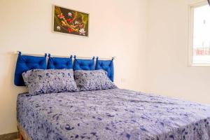 a bed with a blue headboard in a bedroom at Apartamentos estudio amueblados in Punta Cana