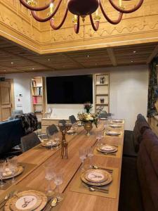 Un comedor con una mesa larga con platos y copas de vino. en Chalet Riedhuus, en Selfranga