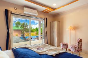 1 dormitorio con 1 cama y puerta corredera de cristal en Malibu Villa by Hill Staytion, en Panchgani