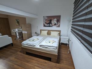 um pequeno quarto com uma cama com lençóis brancos em Apartments Victory em Kavadarci