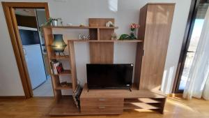 una sala de estar con TV en un centro de entretenimiento de madera en Acogedor y confortable en Torreblanca, en Torreblanca