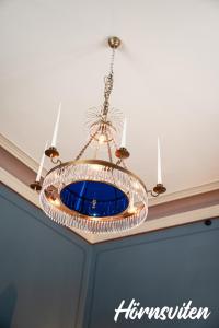 a chandelier hanging from a ceiling in a room at Merlo Slott in Timrå