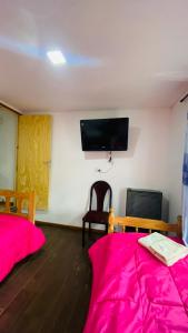 a room with two beds and a flat screen tv at Hope del Bosque in Ushuaia