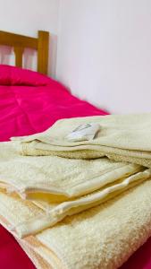 a pile of folded blankets sitting on a bed at Hope del Bosque in Ushuaia