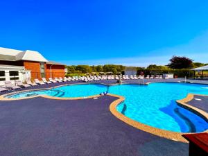 a large swimming pool with lounge chairs in a resort at Cape Cod Irish Village - The Emerald Resort in Barnstable