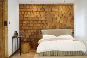sypialnia z ceglaną ścianą i łóżkiem w obiekcie Kamienica Na Nowo Apartamenty Warszawska w mieście Mrągowo