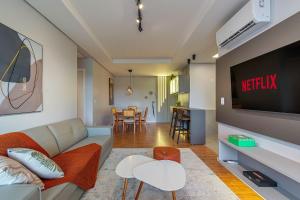 a living room with a couch and a tv at Apto Maua 330 - Stay House Temporada in Canela