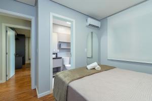 a blue bedroom with a bed and a bathroom at Apto Maua 330 - Stay House Temporada in Canela