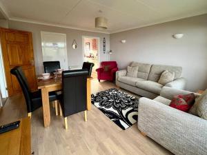 a living room with a couch and a table at 2 Bedroom Seaview Apartment in Pembrokeshire