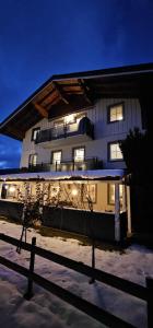 a building with snow on the ground next to a fence at Gästehaus Amadé in Flachau