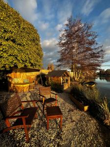 um grupo de cadeiras e uma mesa ao lado de um lago em La cabane romantique de Milly em Milly-sur-Thérain