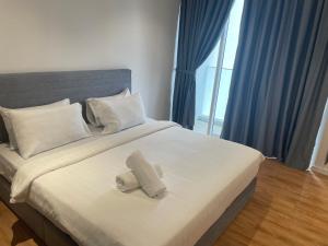 a bedroom with a large bed with two towels on it at Quill Residences A&P KLCC in Kuala Lumpur