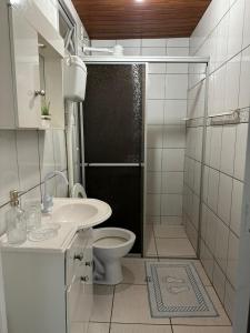 y baño con aseo, lavabo y ducha. en Amplo apart. com sacada com ultra wifi, en Florianópolis