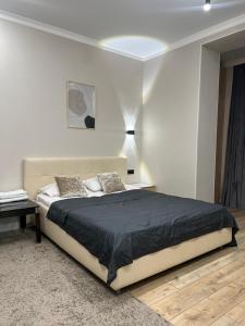 a white bedroom with a large bed and a table at Grand Champion Astana in Taldykolʼ