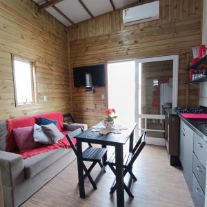 eine Küche und ein Wohnzimmer mit einem Tisch und einem Sofa in der Unterkunft Dunas Tiny House Casa 2 in Florianópolis