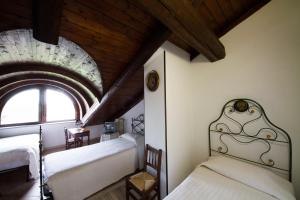 PoirinoにあるAgriturismo La Ca 'd Majinのベッドルーム1室(ベッド2台付)、天井(窓付)が備わります。