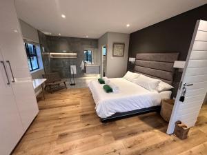 a bedroom with a large bed and a bathroom at SkyJet Villa-Modern, Sophisticated and fun! in Gqeberha
