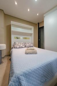 a bedroom with a large bed with a blue blanket at Studios Cor Eucarístico PREMIUM in Belo Horizonte
