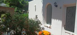 a white house with a door and some flowers at Villa dei fiori B&B in Capri