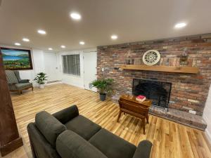 a living room with a couch and a brick fireplace at Lake Pearl House in Lake Placid