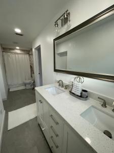 a bathroom with two sinks and a large mirror at Lake Pearl House in Lake Placid +21 photos