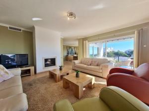 a living room with couches and a tv at Villa Pugna - Private Pool, BBQ, Sauna in Benalmádena