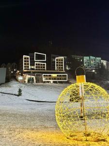 Una gran bola de oro sentada en un estacionamiento por la noche en WinterHome2, en Bjelašnica