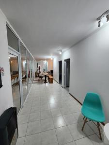 un couloir avec une chaise verte et une table dans l'établissement Benja, à General Pico
