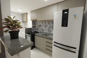 a kitchen with a white refrigerator and a potted plant at Apartamento Luxuoso à 2km da Litorânea in São Luís