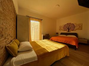 1 dormitorio con 2 camas y ventana en B&b Niu Susu en Lanusei