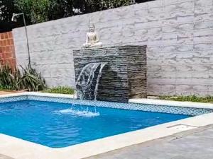 a fountain in a swimming pool with a statue at Cabañas Brisa Bonita Misiones in Posadas