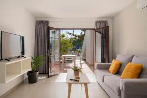 un soggiorno con divano e TV di Apartamentos Fayna a Puerto del Carmen