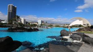 a pool of blue water with a city in the background at Apartamento moderno y familiar Live Santa Cruz Centro in Santa Cruz de Tenerife
