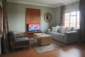 a living room with a couch and a tv at The Meander Estate in Balmoral