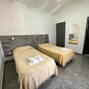 Habitación con 2 camas y toallas. en Hotel Bellavista en Villa Carlos Paz