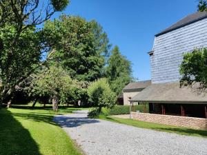 a house with a gravel driveway next to a building at Clos des Rogations in Saint-Hubert