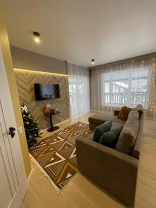 a living room with a couch and a christmas tree at Horizon Apartmens in Yablunytsya