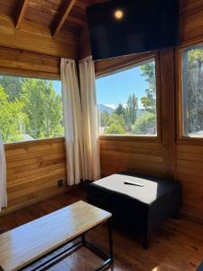 a room with a bed and a large window at Huilen de Bandurrias in San Martín de los Andes