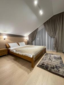 een slaapkamer met een groot bed en een tapijt bij Horizon Apartmens in Yablunytsia